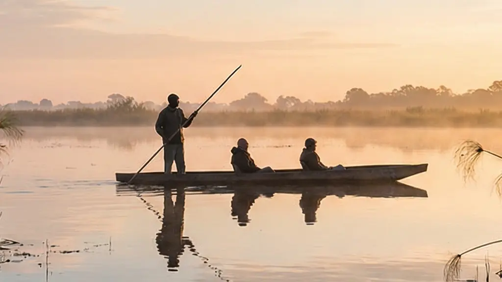 Vue minimaliste d'une pirogue traditionnelle glissant sur une eau calme au lever du jour, illustrant la sérénité et la maîtrise d'un pilote expérimenté